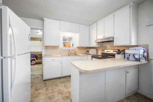 a kitchen with a sink stove and cabinets