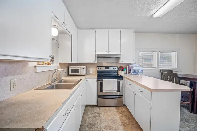 a kitchen with a sink stove and cabinets