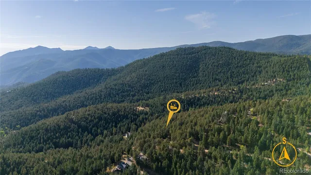 a view of a house with a mountain and a forest