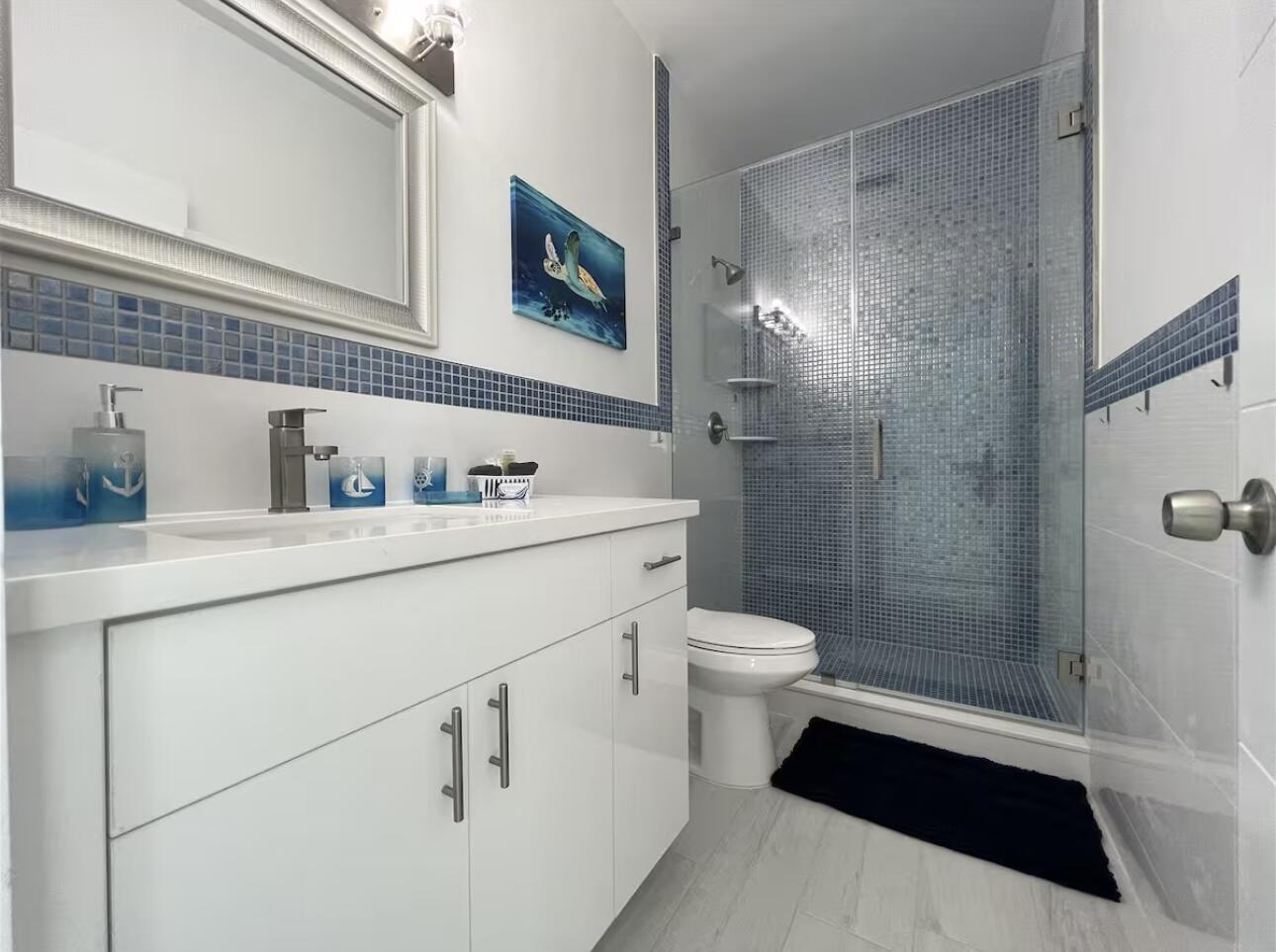 1021 82nd Street Marathon, FL 33050 - Photo 17 of 33 a bathroom with a sink a toilet a shower and a mirror