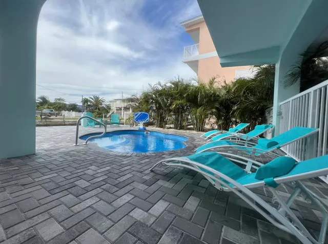 a swimming pool with outdoor seating and yard