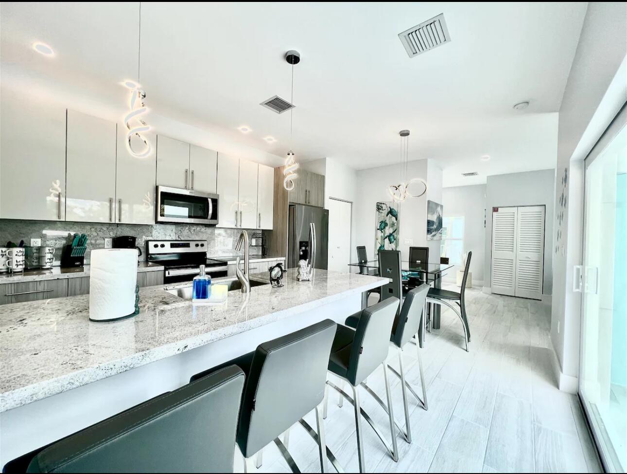 1021 82nd Street Marathon, FL 33050 - Photo 8 of 33 a kitchen with sink cabinets and dining table chairs