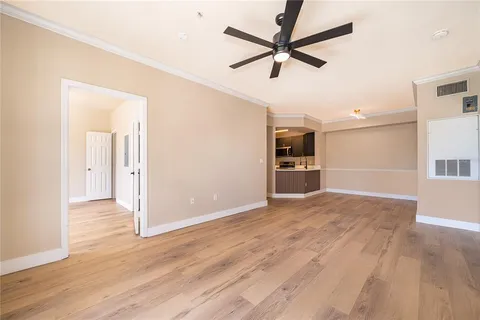 wooden floor in an empty room with a kitchen