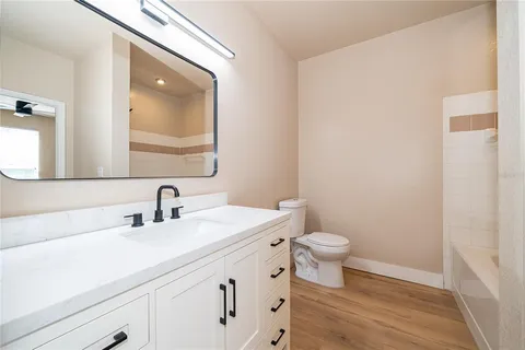 a bathroom with a toilet a sink and a mirror