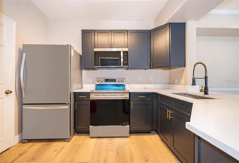 a kitchen with stainless steel appliances a refrigerator sink and microwave