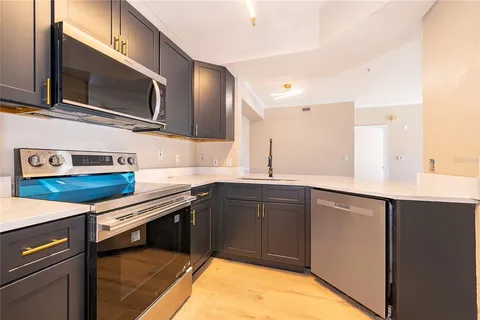a kitchen with stainless steel appliances granite countertop a sink and a stove