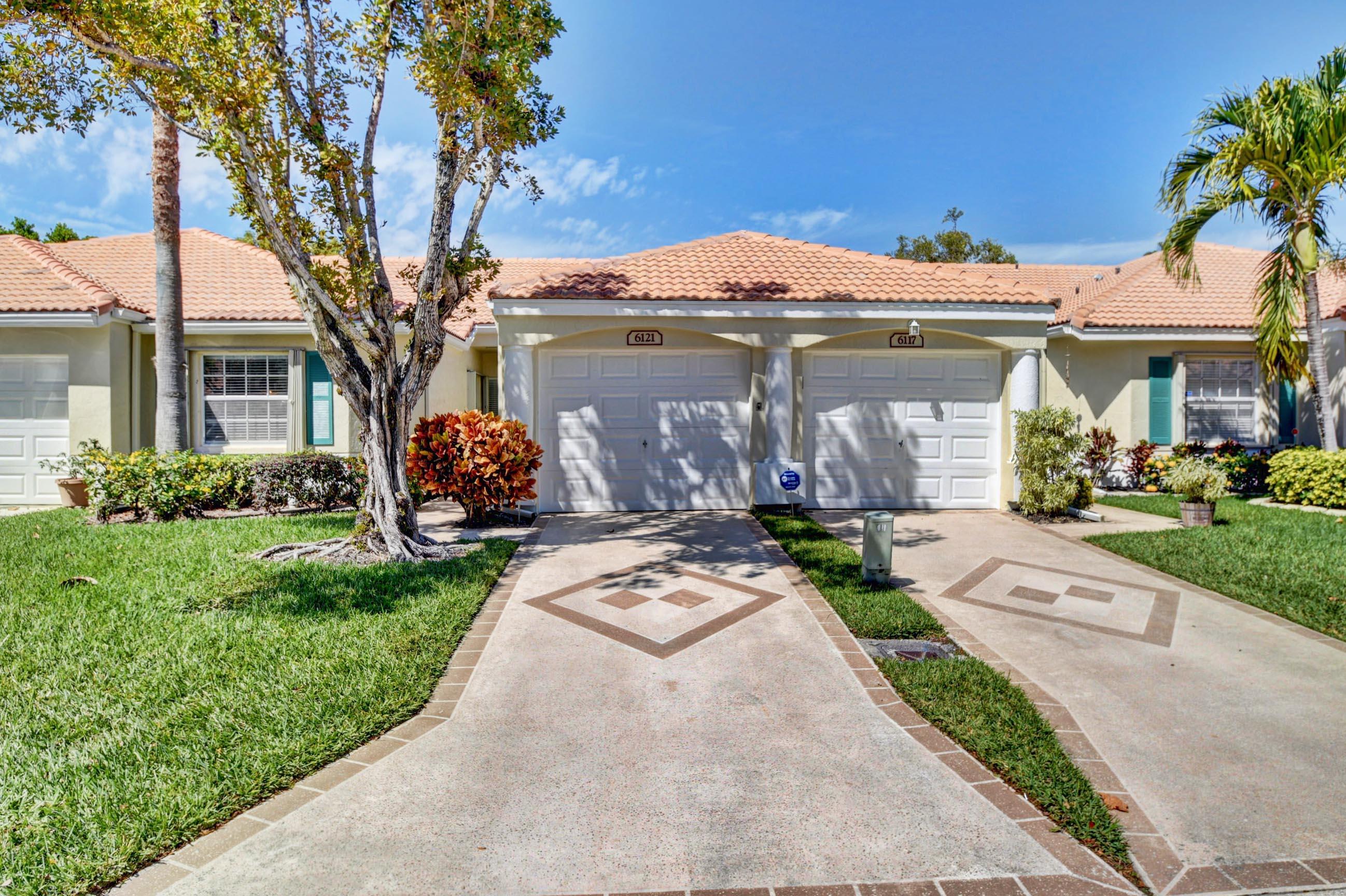 6121 Heliconia Road Delray Beach, FL 33484 - Photo 1 of 49 a front view of a house with garden
