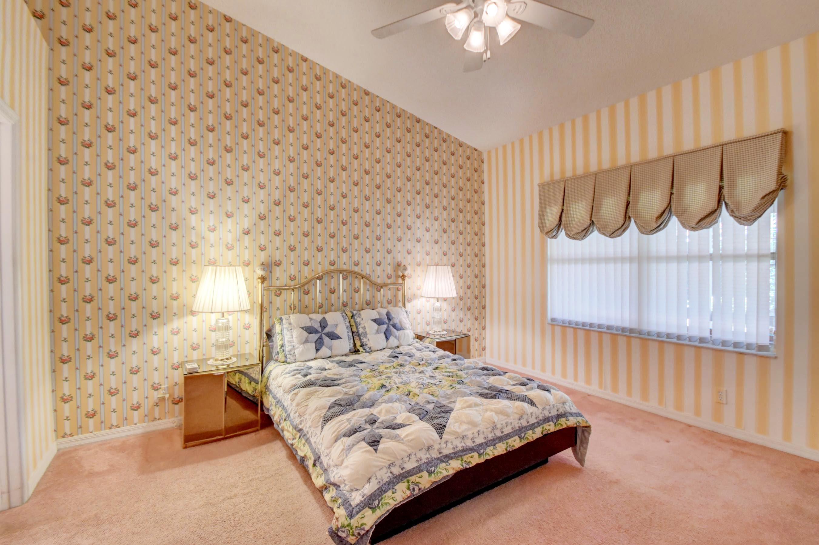 6121 Heliconia Road Delray Beach, FL 33484 - Photo 18 of 49 a bedroom with a bed and a wall painting