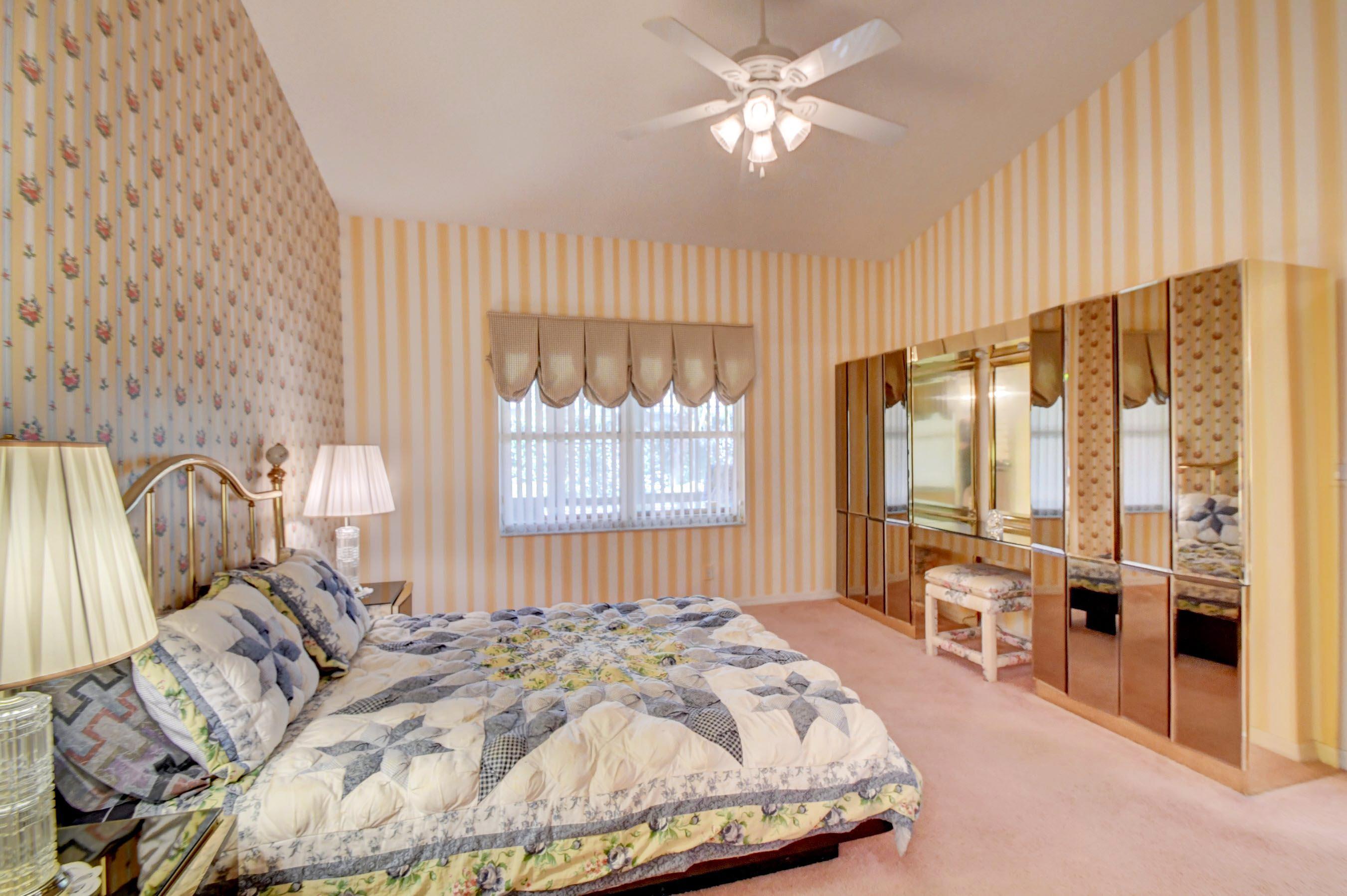 6121 Heliconia Road Delray Beach, FL 33484 - Photo 19 of 49 a bed sitting in a spacious bedroom next to a window