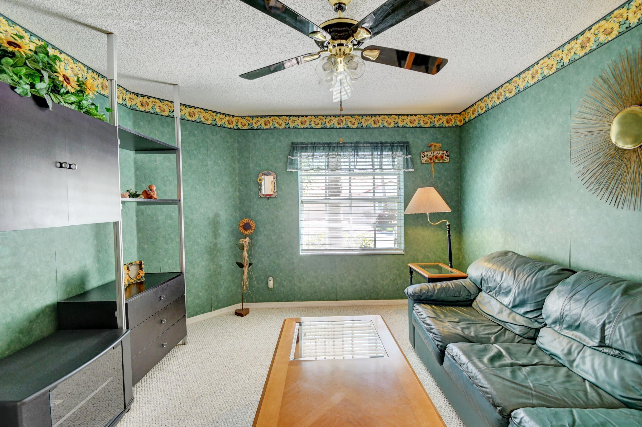 6121 Heliconia Road Delray Beach, FL 33484 - Photo 23 of 49 a spacious bedroom with a bed and a chandelier