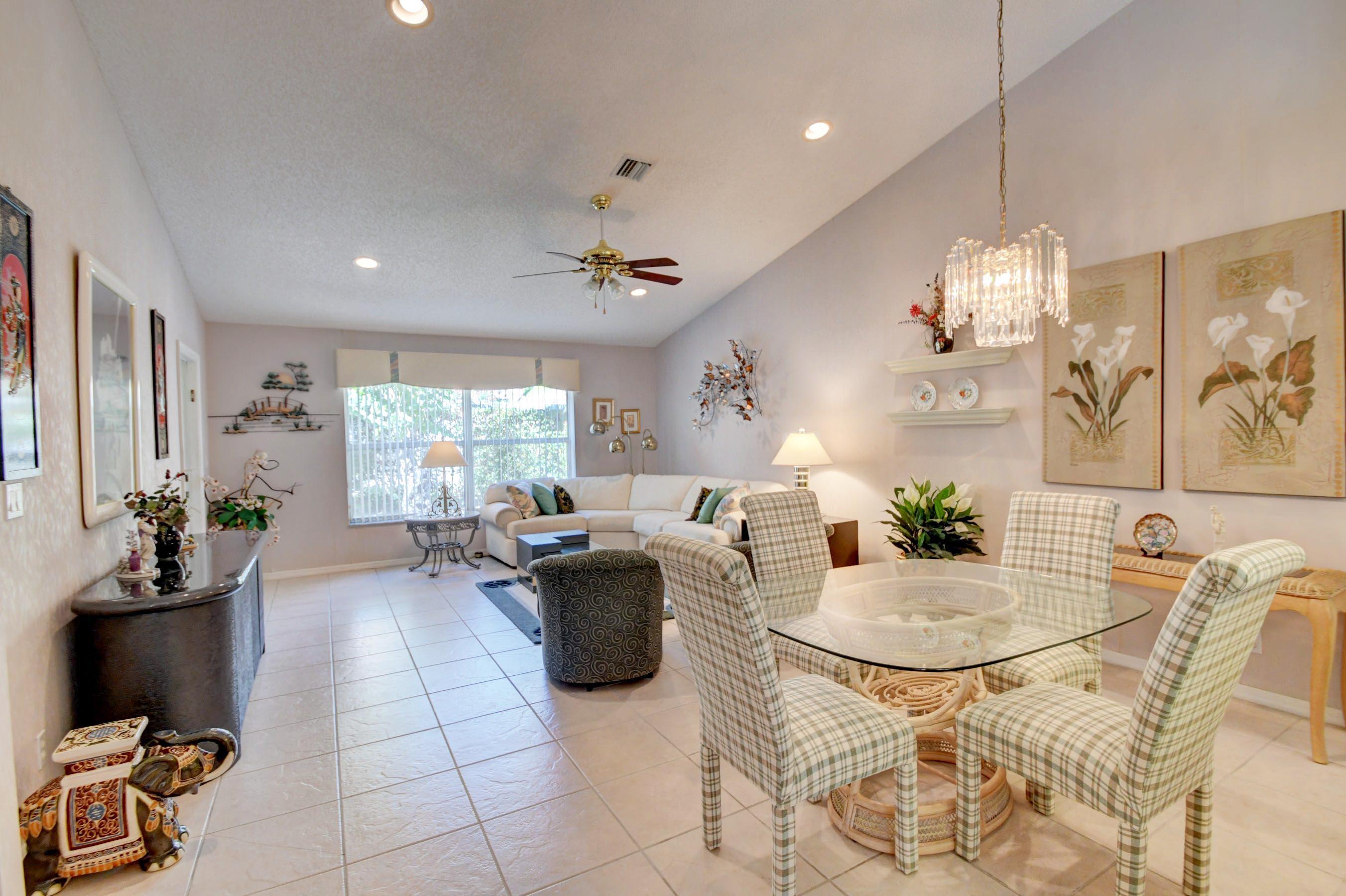 6121 Heliconia Road Delray Beach, FL 33484 - Photo 8 of 49 a living room with furniture a chandelier and a dining table