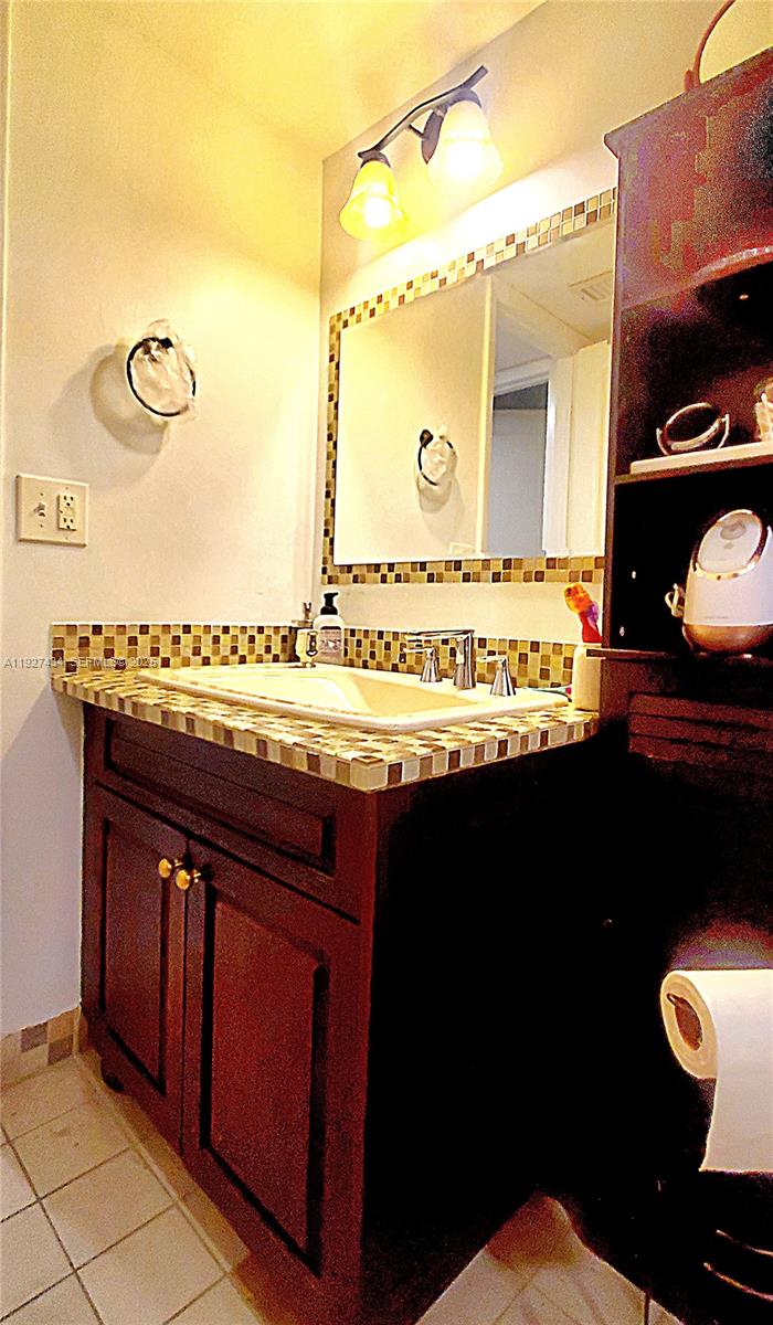 3905 North Nob Hill Road, Unit 510 Sunrise, FL 33351 - Photo 12 of 60 a bathroom with a granite countertop sink and a mirror