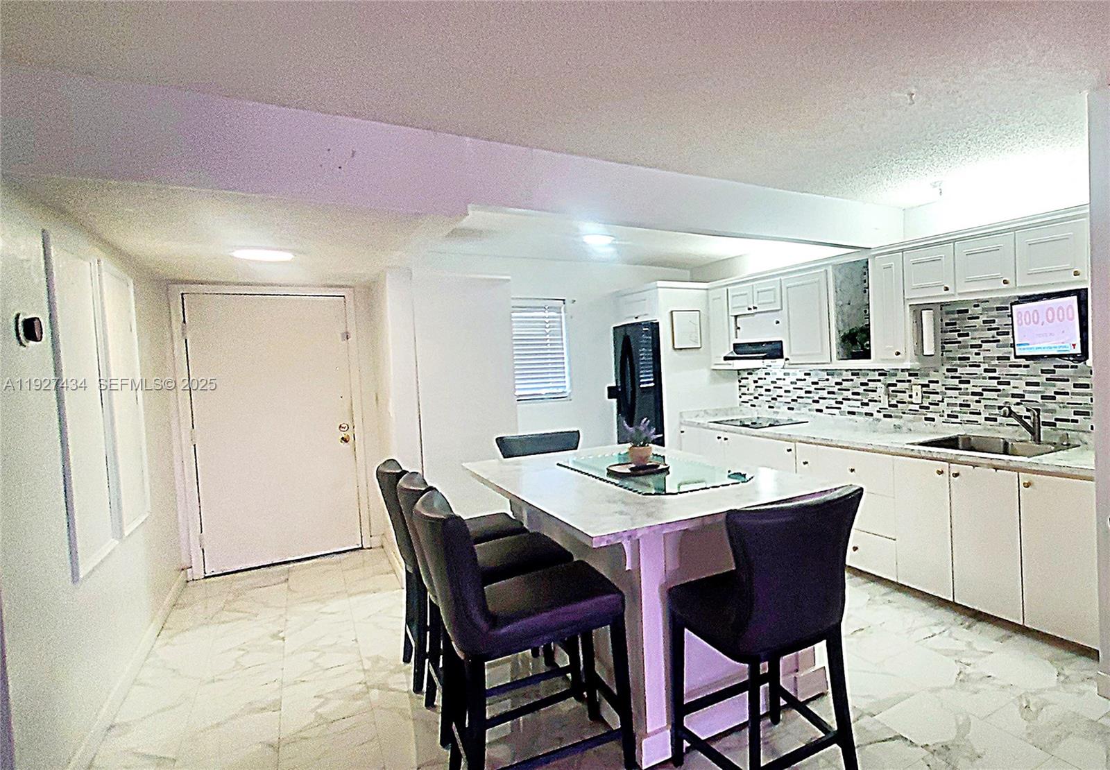 3905 North Nob Hill Road, Unit 510 Sunrise, FL 33351 - Photo 24 of 60 a kitchen with a dining table chairs and white cabinets