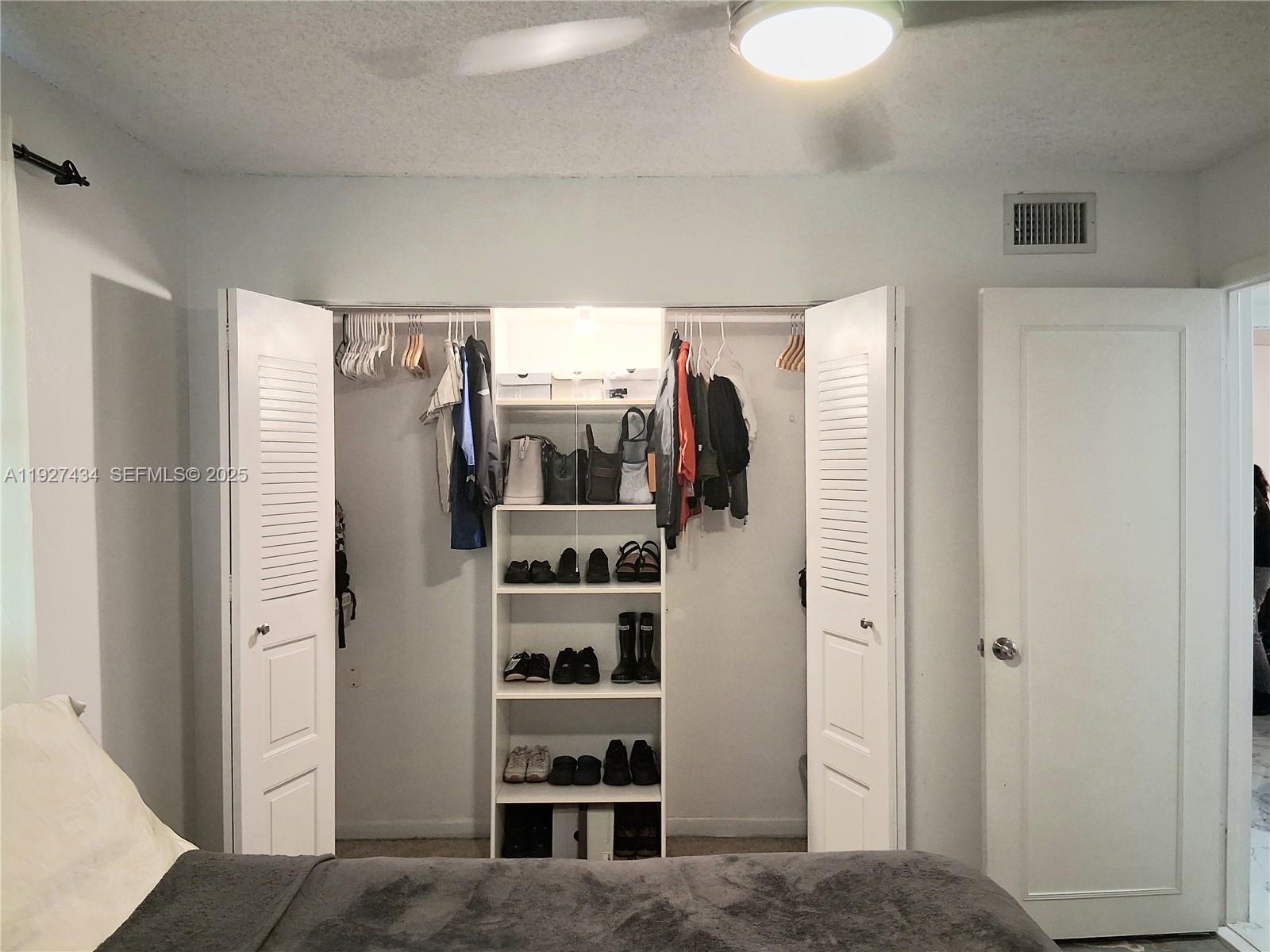 3905 North Nob Hill Road, Unit 510 Sunrise, FL 33351 - Photo 33 of 60 a view of walk in closet with clothes and shoes