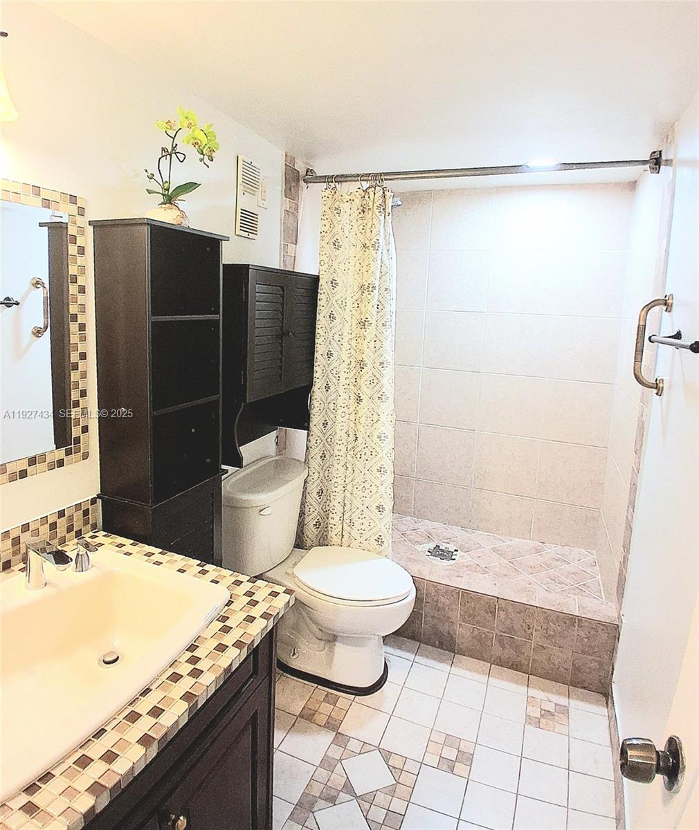 3905 North Nob Hill Road, Unit 510 Sunrise, FL 33351 - Photo 60 of 60 a bathroom with a granite countertop sink toilet and shower