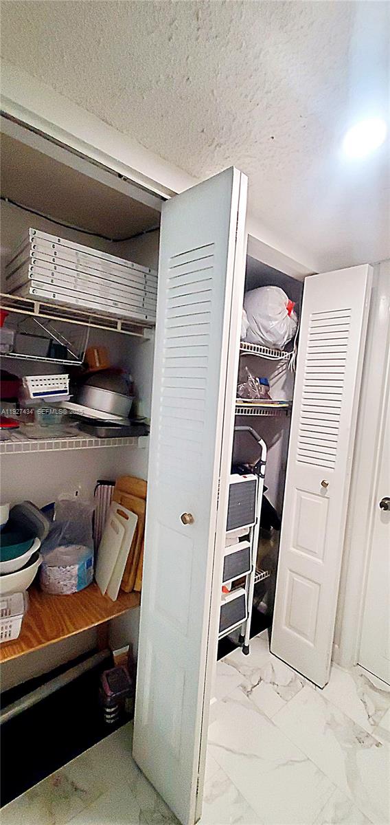 3905 North Nob Hill Road, Unit 510 Sunrise, FL 33351 - Photo 10 of 60 a view of walk in closet with clothes and shoes