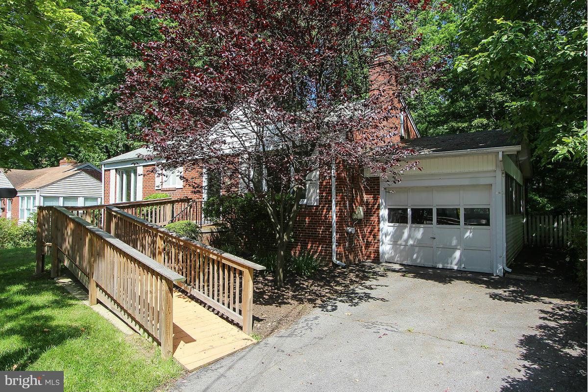 1304 Chalmers Road Silver Spring, MD 20903 - Photo 2 of 19 a view of a house with wooden fence and a large tree