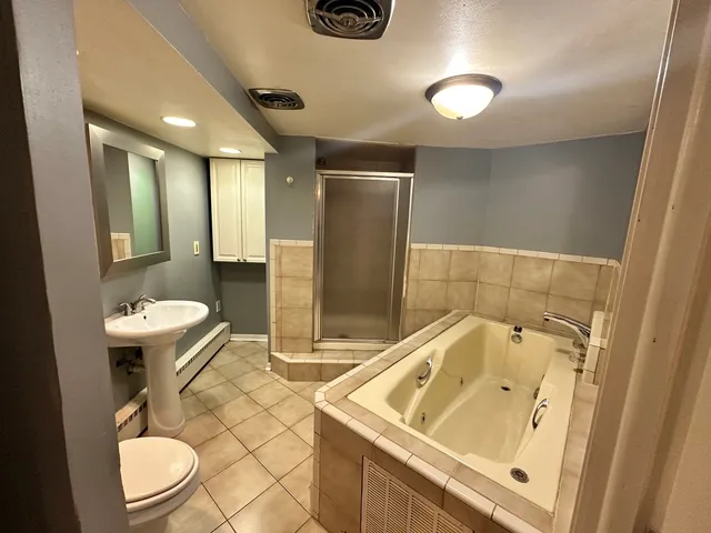 a bathroom with a sink a toilet and shower