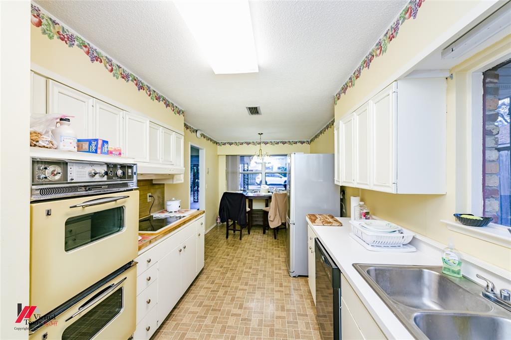 1404 North Acres Circle Springhill, LA 71075 - Photo 11 of 29 Kitchen featuring white cabinetry, black appliances, decorative light fixtures, and a textured ceiling