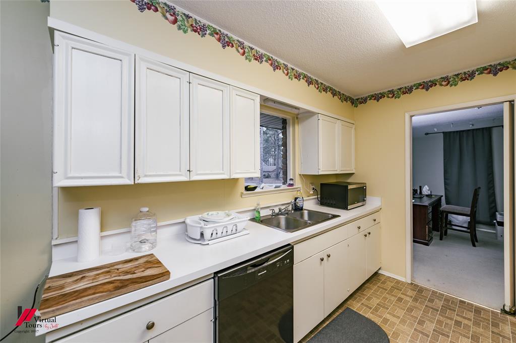 1404 North Acres Circle Springhill, LA 71075 - Photo 17 of 29 Kitchen with white cabinetry, black dishwasher, light countertops, and a textured ceiling
