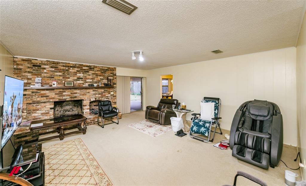 1404 North Acres Circle Springhill, LA 71075 - Photo 20 of 29 Living area with carpet floors, a fireplace, and a textured ceiling
