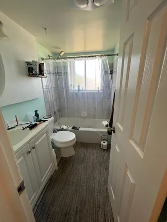 a bathroom with a sink a toilet a mirror and shower