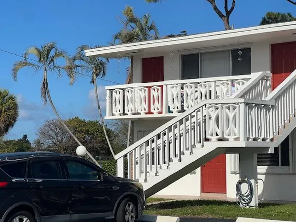 a view of a house with wooden deck and a yard