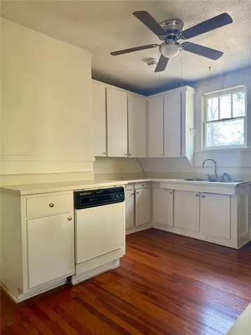 a kitchen with granite countertop white cabinets and white appliances