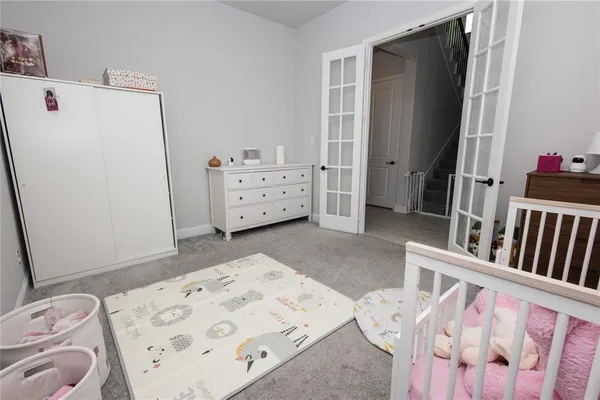 a bedroom with a bed and a refrigerator