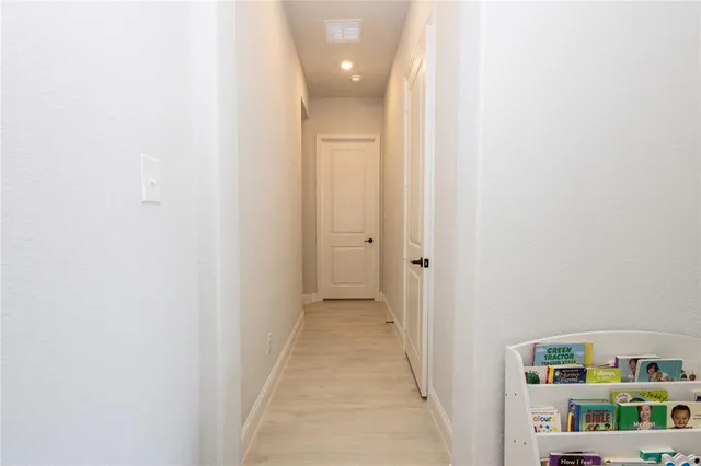 a view of a hallway with closet and window