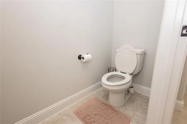a white toilet sitting in a bathroom and a sink
