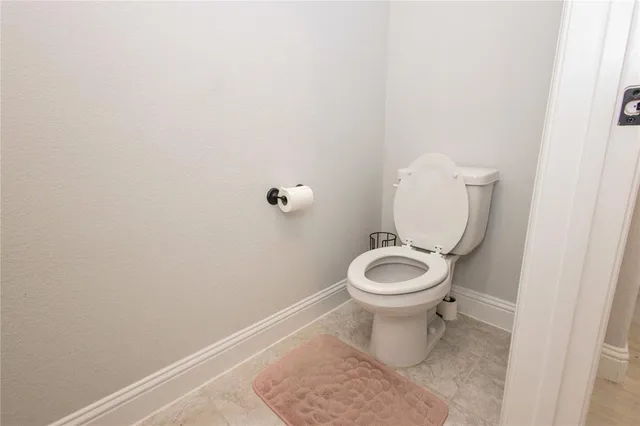 a white toilet sitting in a bathroom and a sink