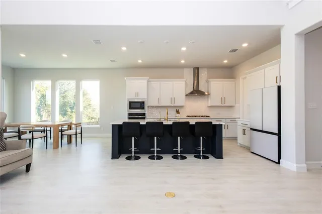 a large white kitchen with lots of counter space and furniture
