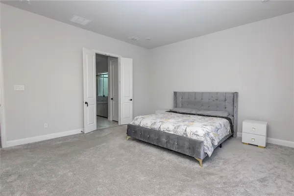 a spacious bedroom with a bed and a cabinets