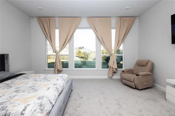 a spacious bedroom with a bed and a large window