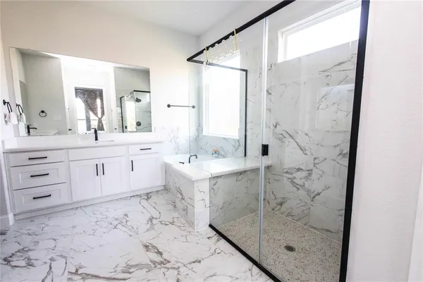 a bathroom with a sink mirror and a shower