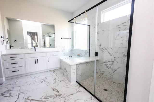 a bathroom with a sink mirror and a shower