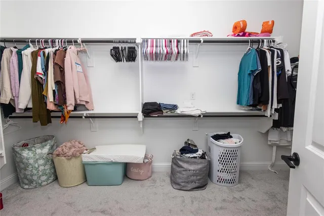 a view of walk in closet with clothes and shoes