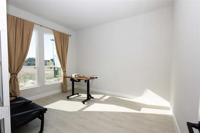 a view of a room with a window and wooden floor