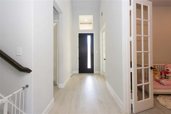 a view of a hallway with wooden floor and entryway