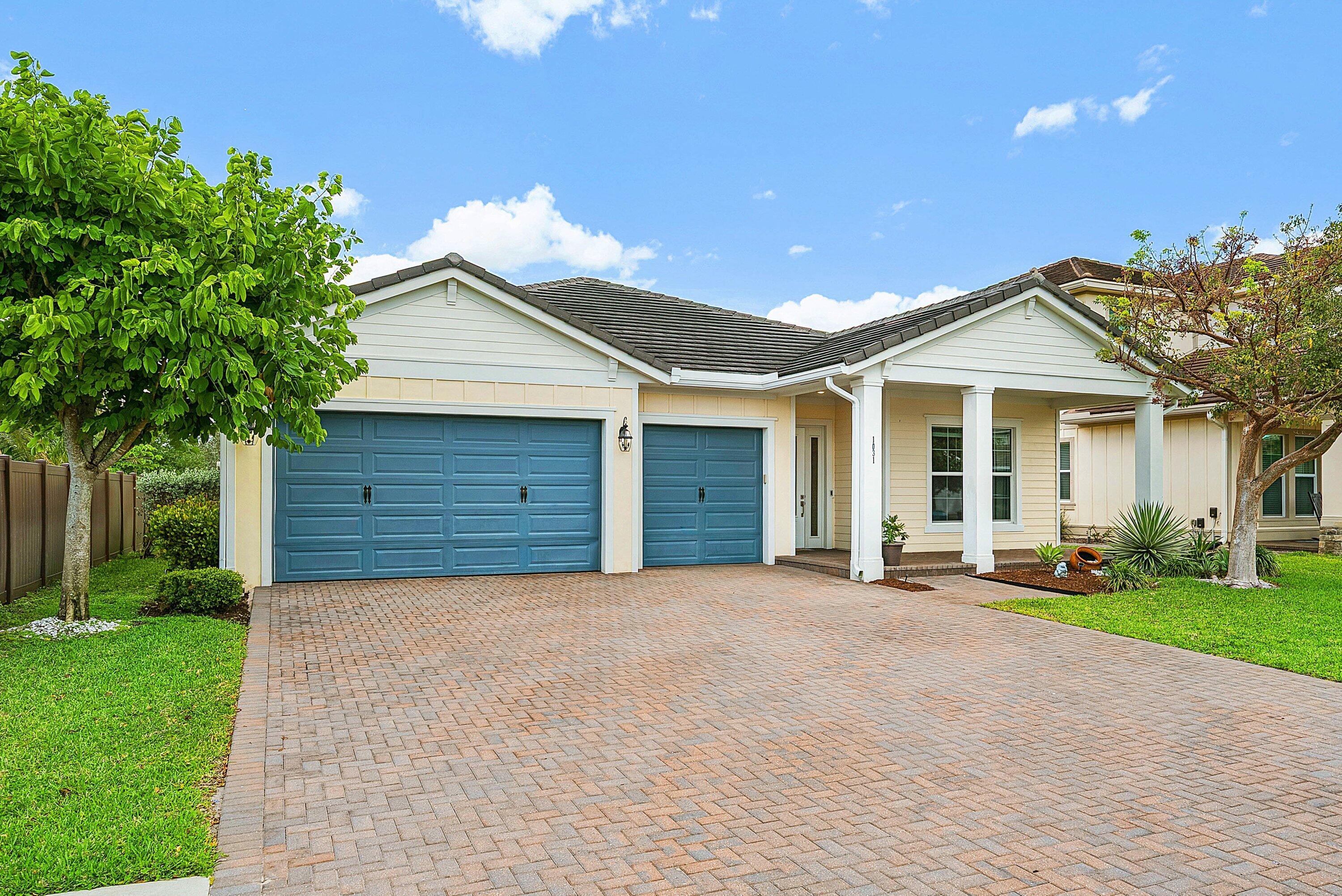 1031 Ember Ridge Run Loxahatchee, FL 33470 - Photo 1 of 52 a front view of a house with a garden and trees