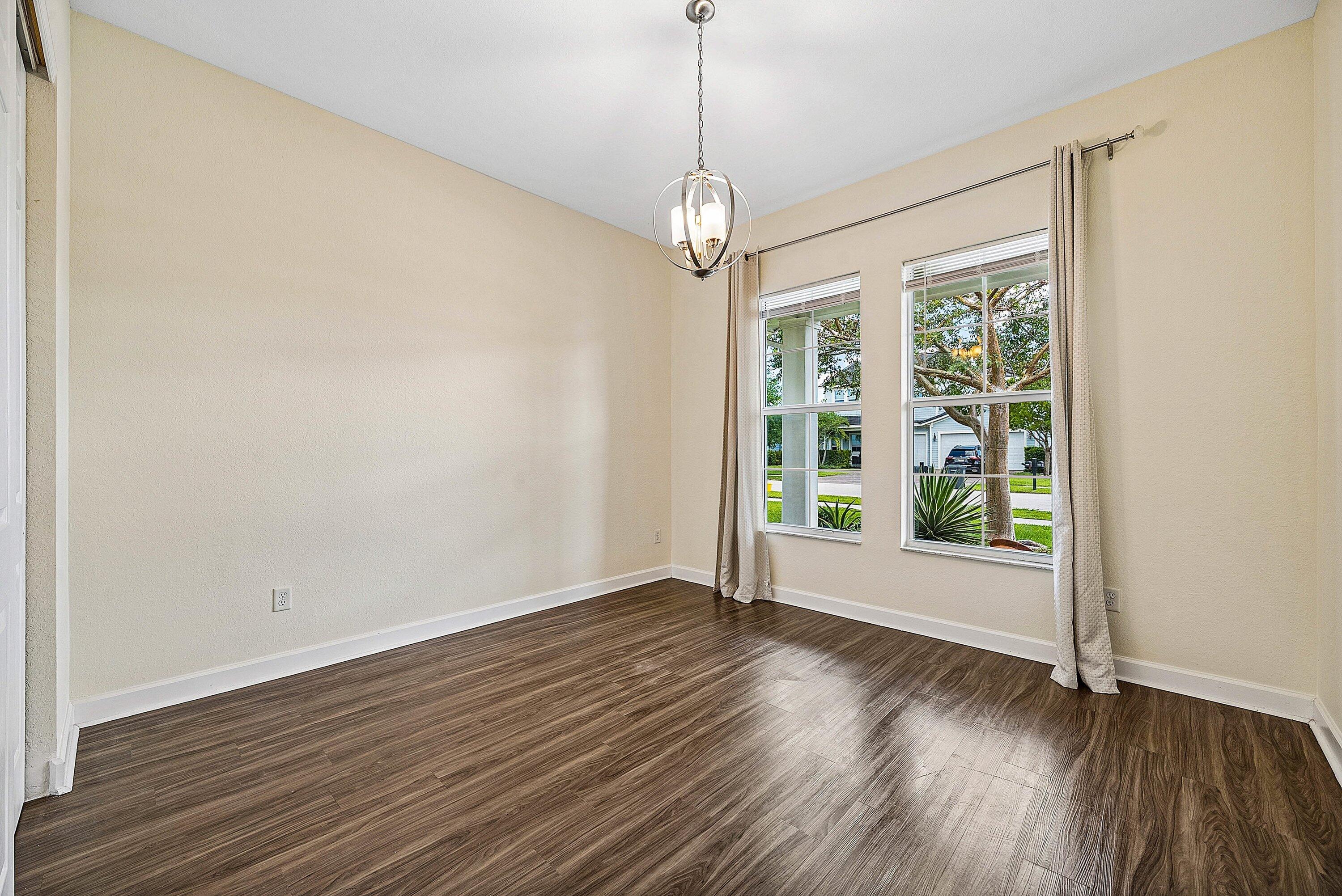 1031 Ember Ridge Run Loxahatchee, FL 33470 - Photo 14 of 52 a view of an empty room with wooden floor and a window