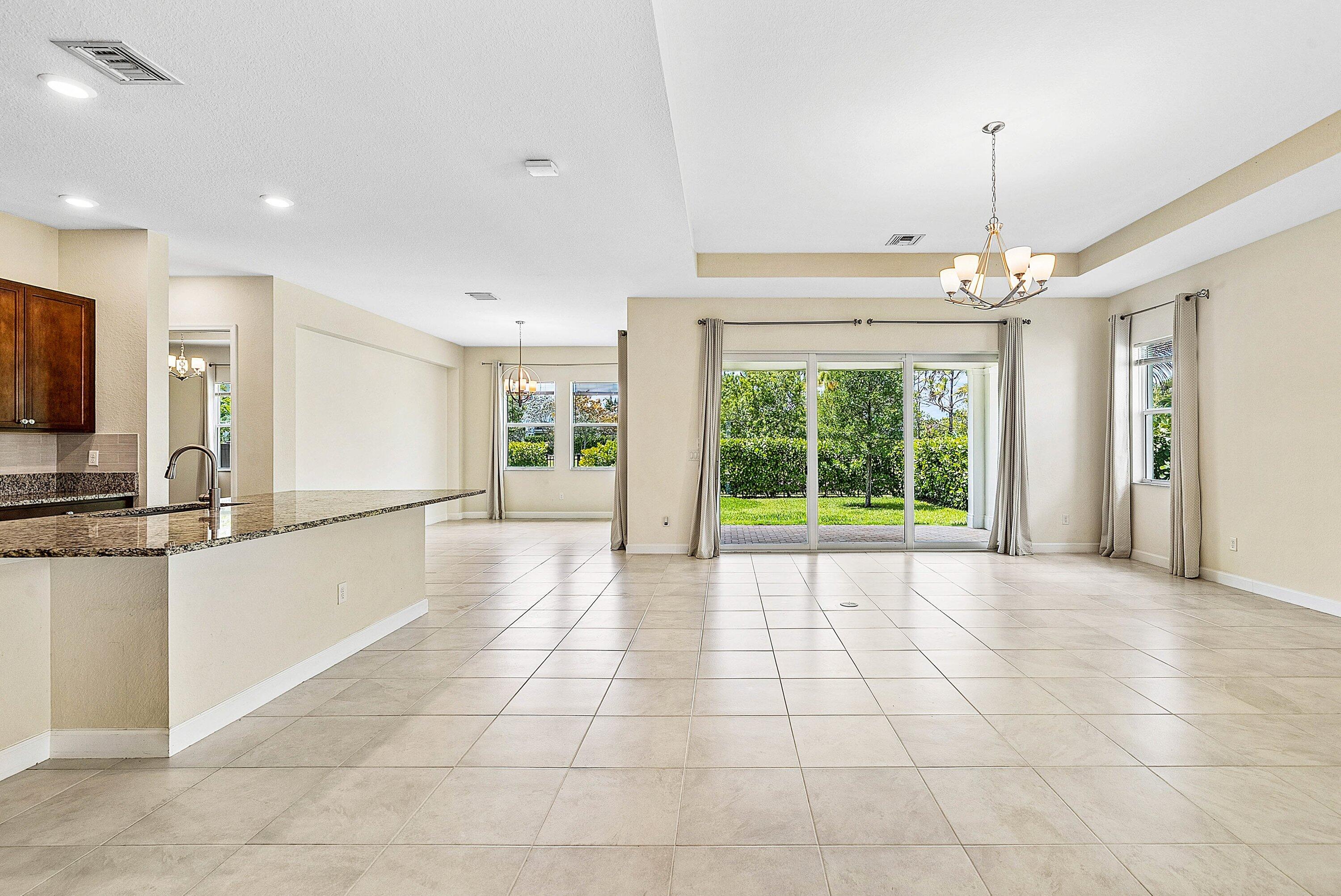 1031 Ember Ridge Run Loxahatchee, FL 33470 - Photo 18 of 52 a large kitchen with kitchen island granite countertop a large window and a sink