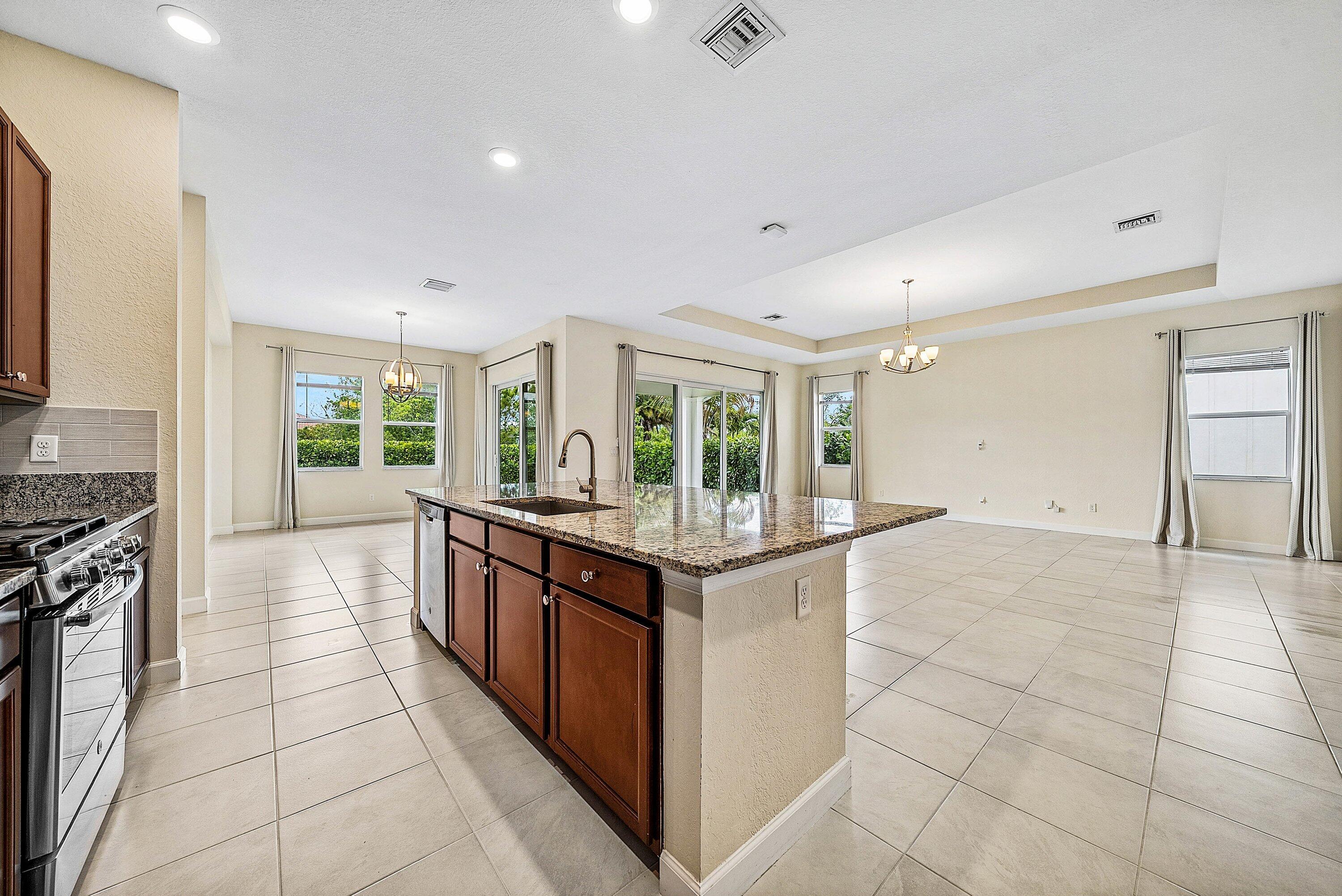 1031 Ember Ridge Run Loxahatchee, FL 33470 - Photo 25 of 52 a kitchen with stainless steel appliances granite countertop a stove and a sink
