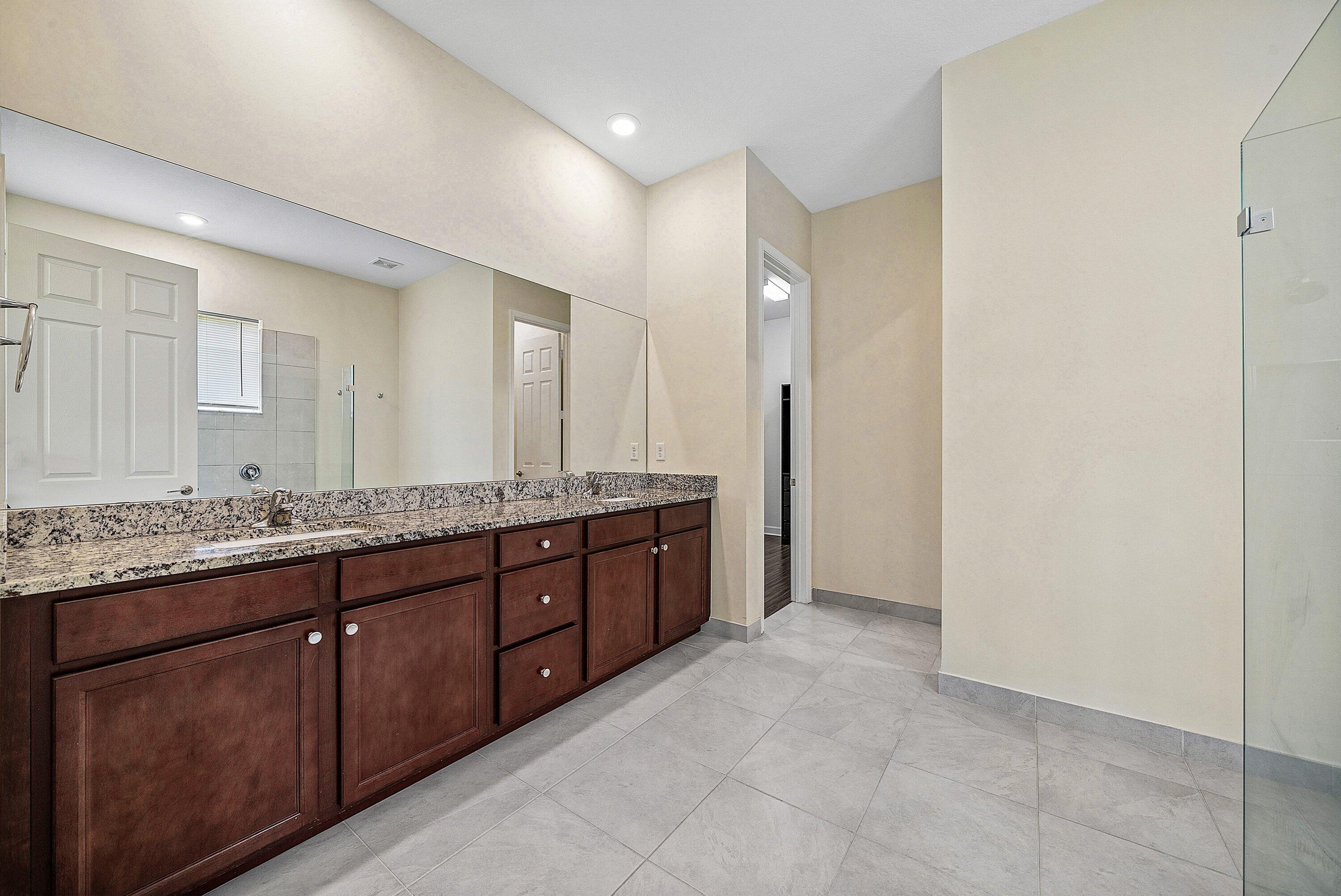 1031 Ember Ridge Run Loxahatchee, FL 33470 - Photo 30 of 52 a bathroom with a granite countertop double vanity sink and a mirror