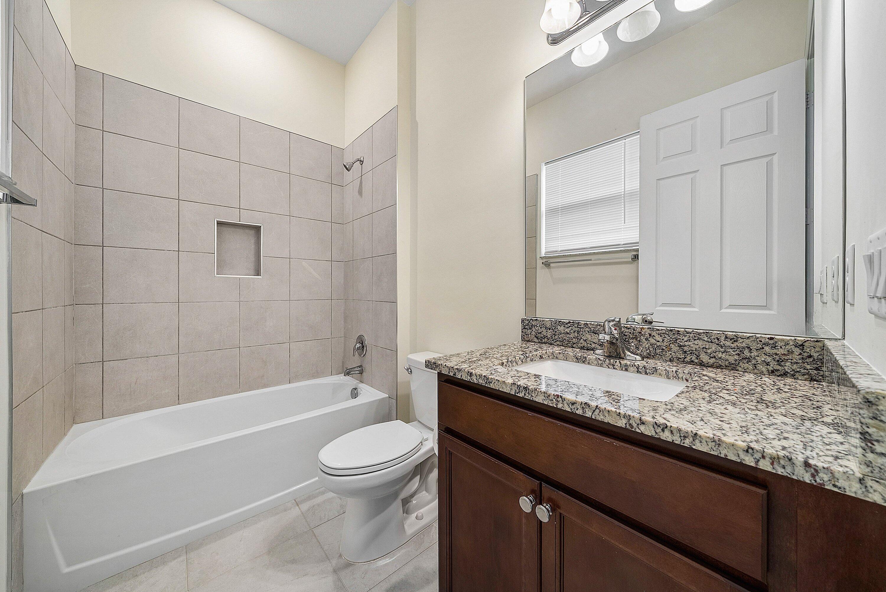 1031 Ember Ridge Run Loxahatchee, FL 33470 - Photo 34 of 52 a bathroom with a granite countertop bathtub sink vanity mirror and toilet