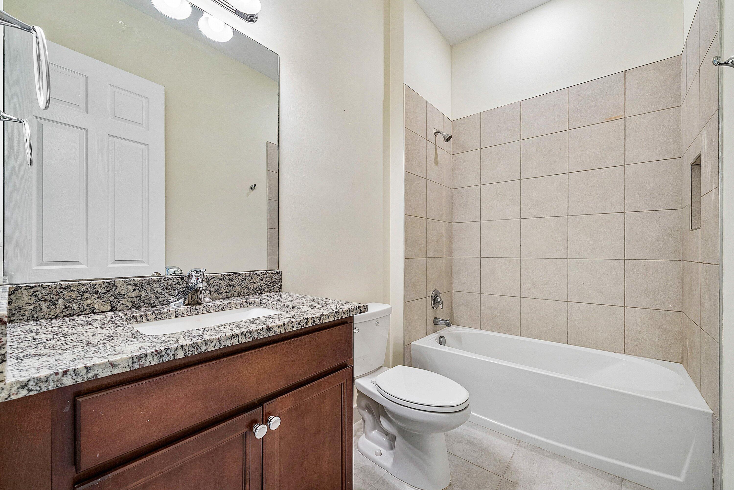 1031 Ember Ridge Run Loxahatchee, FL 33470 - Photo 37 of 52 a bathroom with a granite countertop bathtub sink vanity mirror and toilet