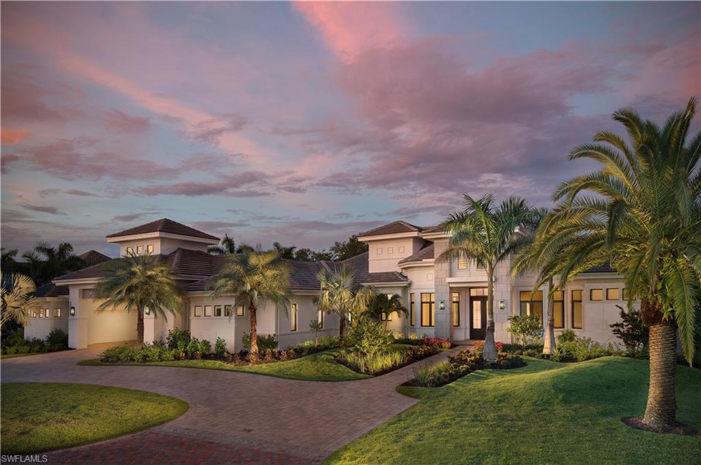 front view of house with a yard and palm trees