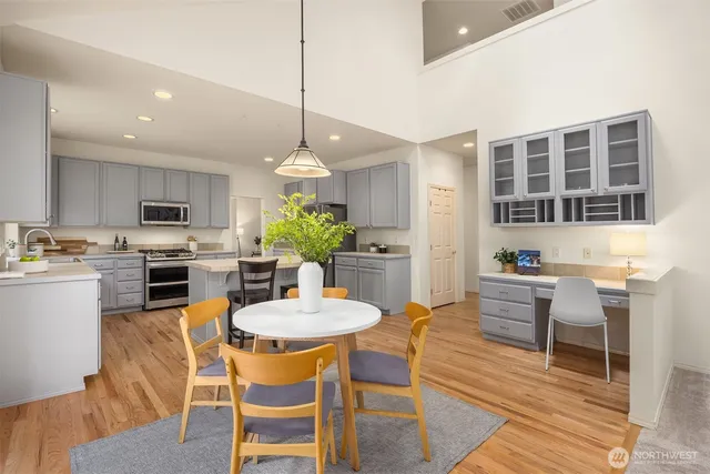 a dining room with wooden floor a chandelier a wooden table and chairs