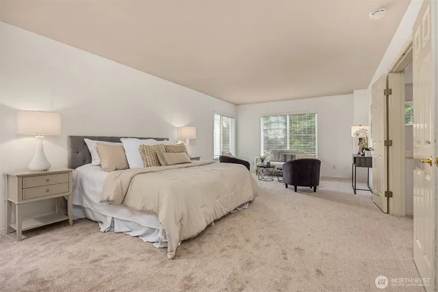 a spacious bedroom with a bed and dresser next to a window